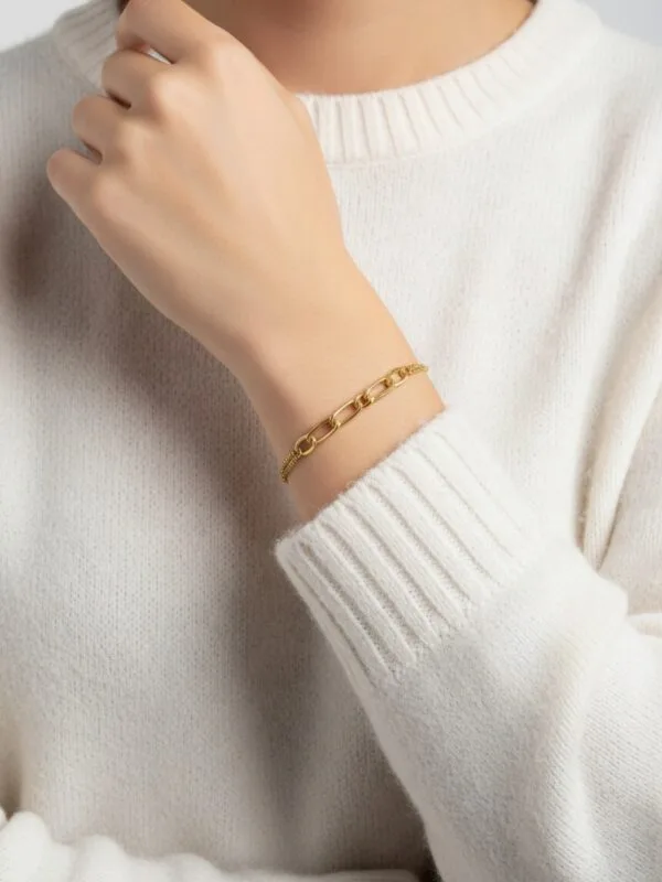 Gold kaplama figaro zincir modeli kadın gümüş bileklik beyaz kazaklı bir kadında bilekte duruşu