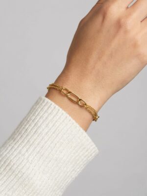 Figaro model kadın zincir bileklik modelinin beyaz kazaklı mankenimizin bileğinde farklı bir açıdan görünümü