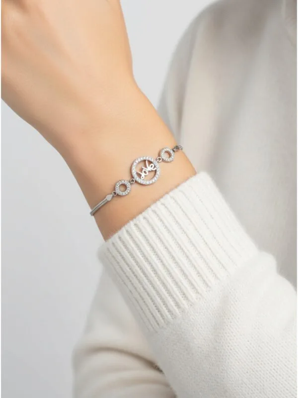 ingilizcede aşk anlamına gelen love yazılı zirkon taşlı kadın bileklik modelimizin beyaz kazaklı mankende duruşu