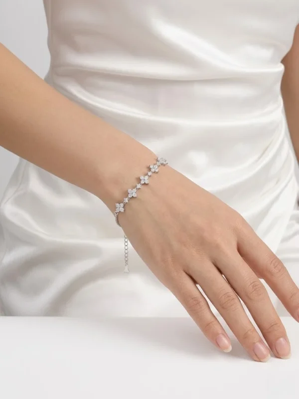 beş sıra çiçek motifli beyaz taşlı gümüş bilekliğin kadın mankende duruşu